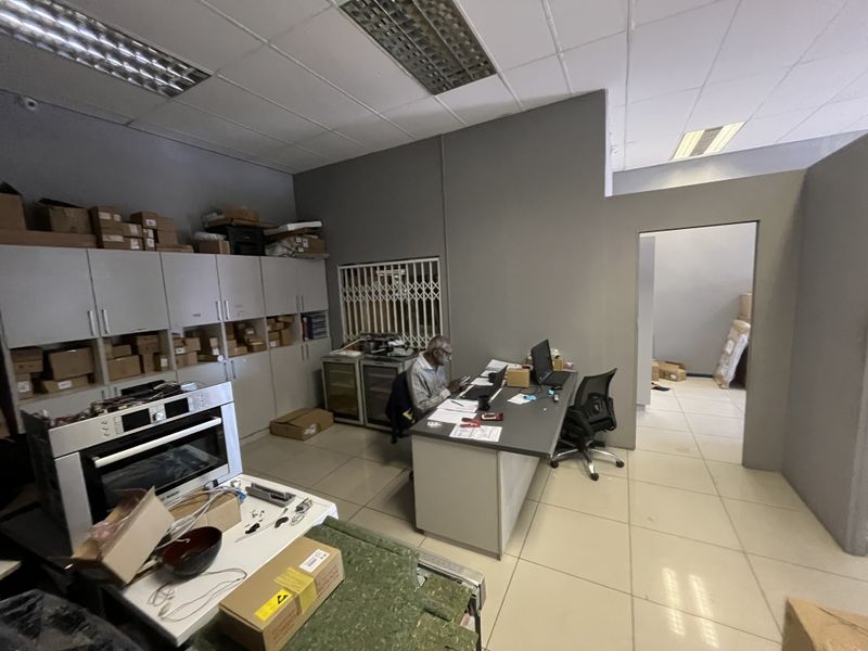 Functional office space featuring built-in cabinetry, tiled flooring, and recessed ceiling lighting, suitable for administrative or commercial use.