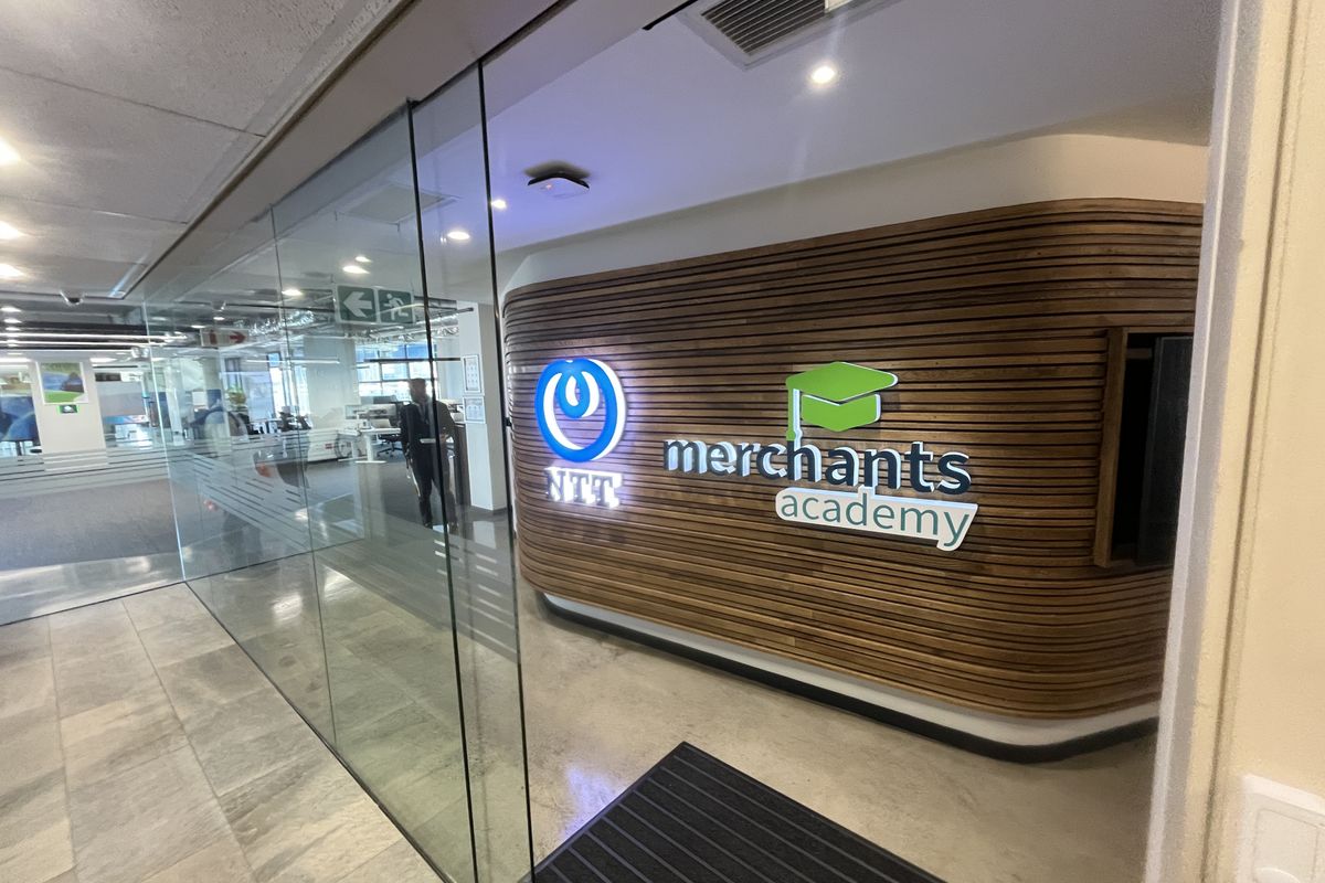 Modern office entrance featuring a glass partition wall and a prominent slatted timber feature wall with corporate branding.