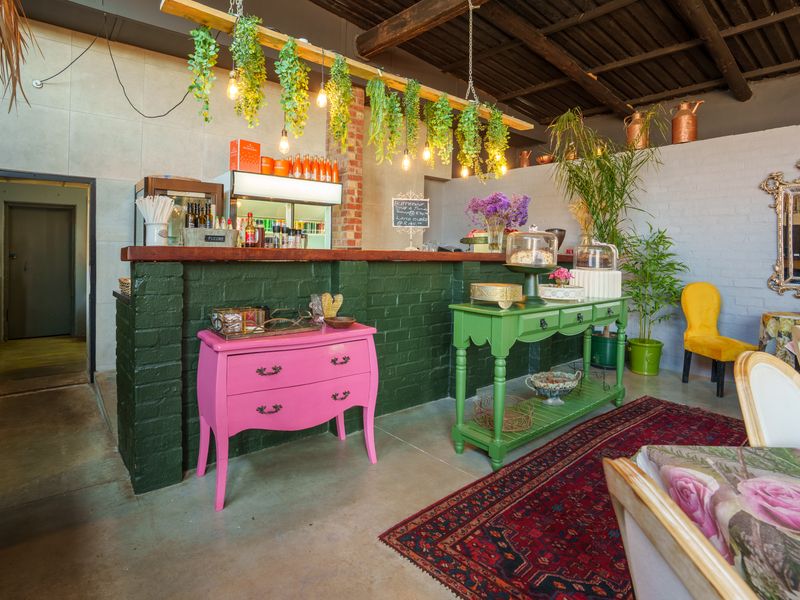 A rustic restaurant interior featuring a painted brick service counter, exposed timber ceiling beams, and polished concrete flooring with a warm, inviting atmosphere.
