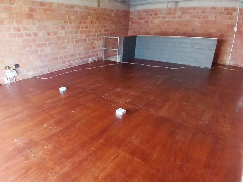 An empty office space featuring exposed brick walls, timber flooring, and an industrial-style exposed ceiling, offering a blank canvas for custom fit-out.