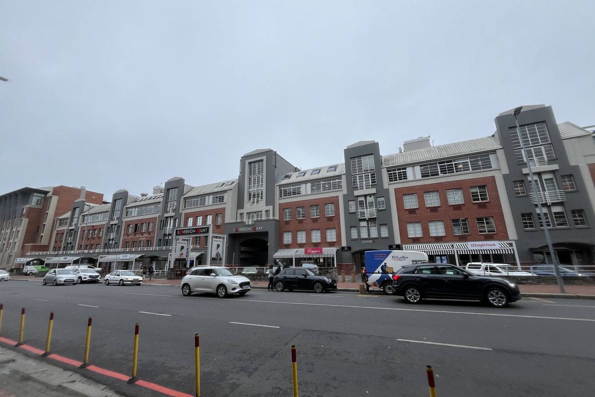 Street-level view of the Sovereign Quay office complex, featuring a multi-story brick and grey facade with ground-floor commercial access.