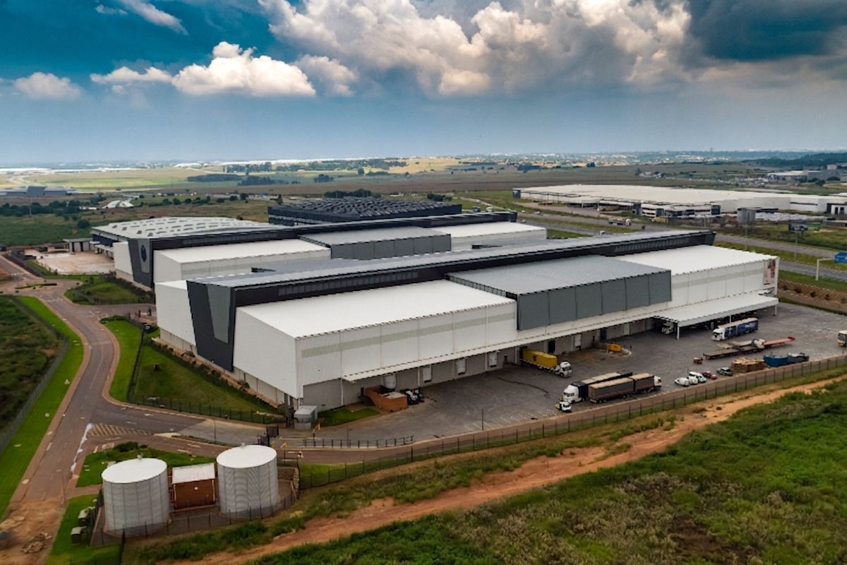 Aerial view of a large industrial warehouse complex featuring multiple loading docks, extensive yard space, and on-site water storage tanks.