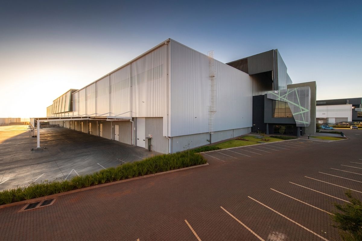 Modern industrial warehouse facility featuring extensive loading bays, paved parking, and high-quality metal cladding exterior.