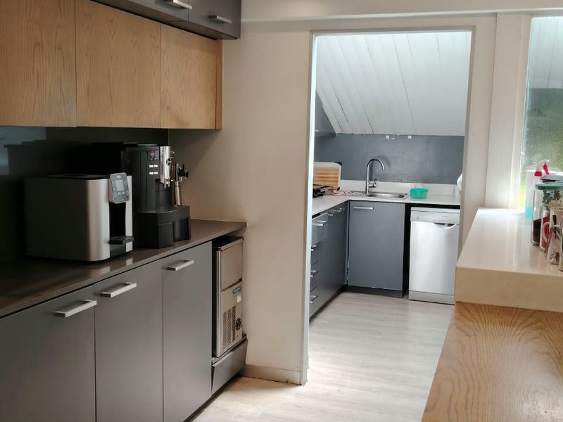 Modern kitchen featuring sleek grey cabinetry, integrated appliances, and a functional scullery area with additional sink and dishwasher.