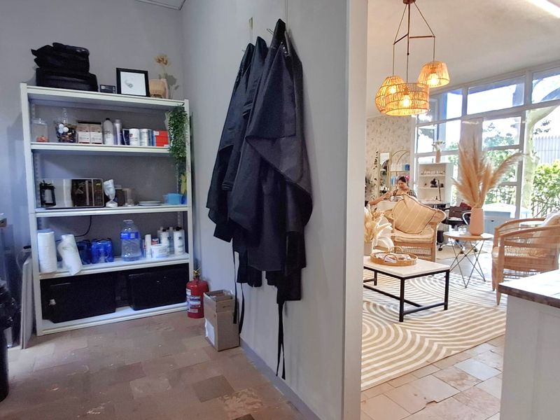 A functional office space featuring large windows for natural light, pendant lighting, and tiled flooring, providing a bright and open work environment.