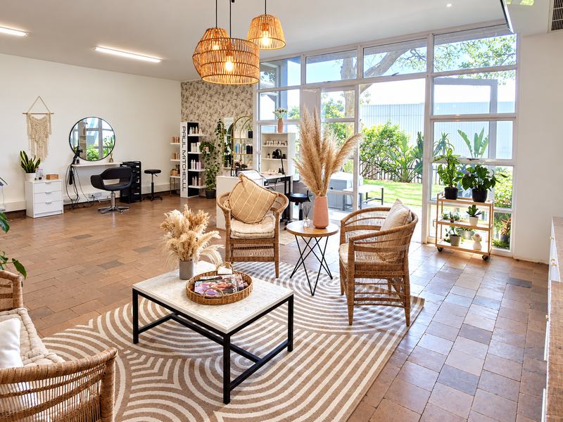 A bright and spacious office area featuring large glass windows, tiled flooring, and modern recessed lighting, creating an inviting and professional workspace environment.