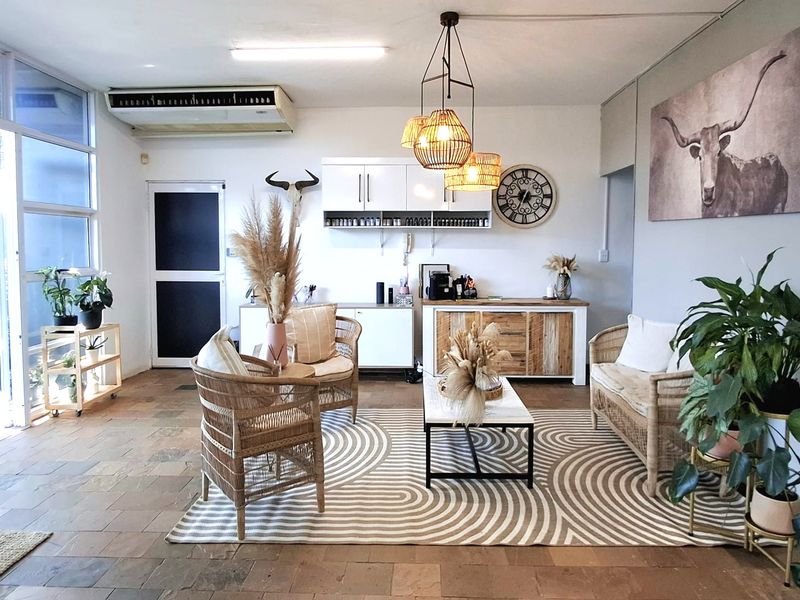 A bright and inviting office space featuring stone tile flooring, built-in cabinetry, and large glass windows that provide ample natural light.