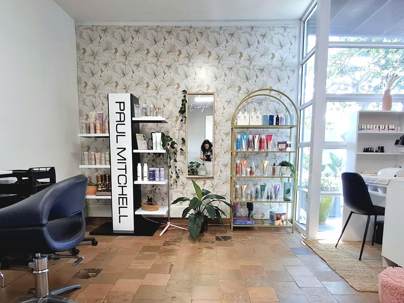 A bright office or salon space featuring large glass windows, decorative floral wallpaper, and durable tiled flooring, offering a welcoming and well-lit professional environment.