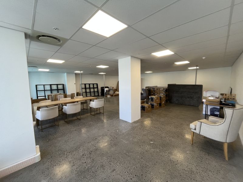 Open-plan office space featuring polished concrete floors, suspended ceiling tiles, and recessed LED lighting, offering a versatile and modern professional work environment.