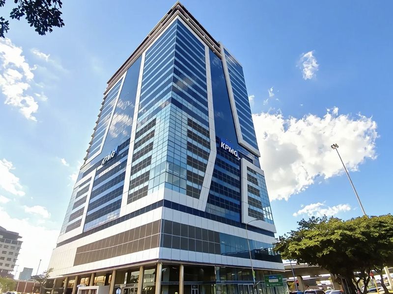 A modern high-rise commercial office building featuring a prominent glass curtain wall facade and contemporary architectural design.