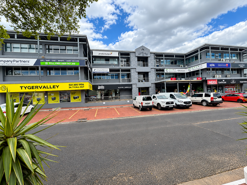 Front view of the Edward III office complex featuring a multi-level facade with paved parking and prominent commercial signage.