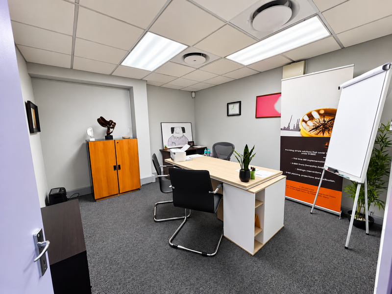 A professional office space featuring a suspended ceiling with recessed lighting and carpeted flooring, providing a functional and well-maintained work environment.