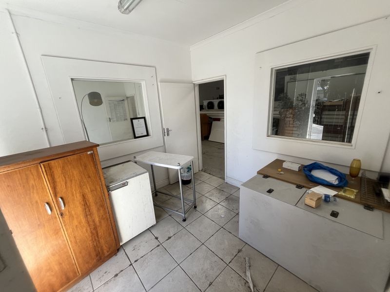 A functional utility space featuring tiled flooring and internal windows, providing a practical area for storage or workspace needs.