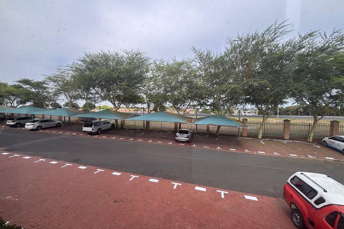 An elevated view of the office property's parking area, featuring paved bays and shaded parking structures.