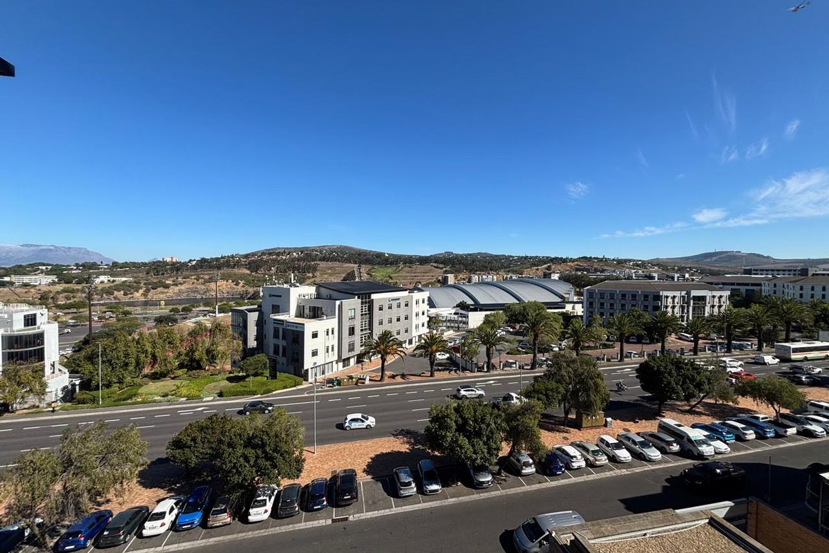 Elevated aerial view overlooking a commercial office precinct, surrounding infrastructure, and landscaped grounds with ample parking facilities.