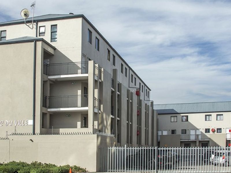 Exterior view of the Parc du Ville apartment complex featuring multi-story residential blocks with balconies and secure perimeter fencing.