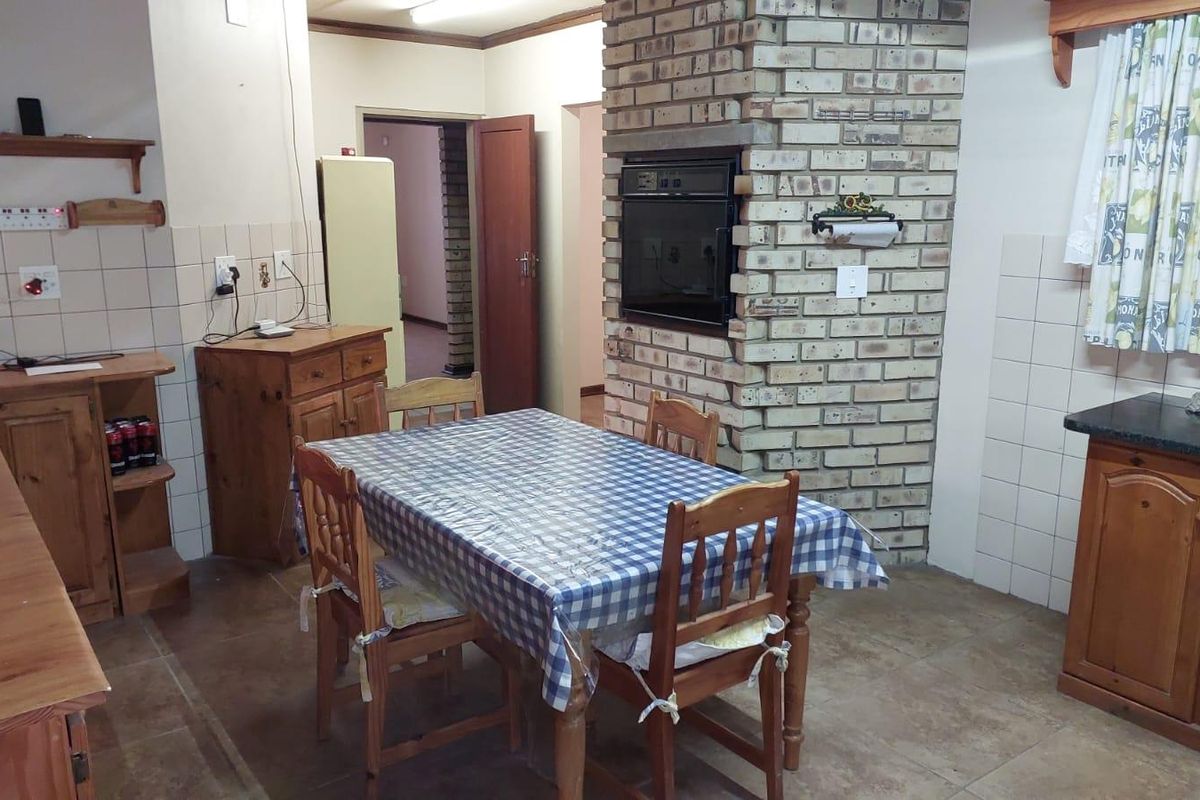 A functional kitchen featuring built-in cabinetry, a brick-encased wall oven, and tiled surfaces, offering a traditional layout with potential for modernization.