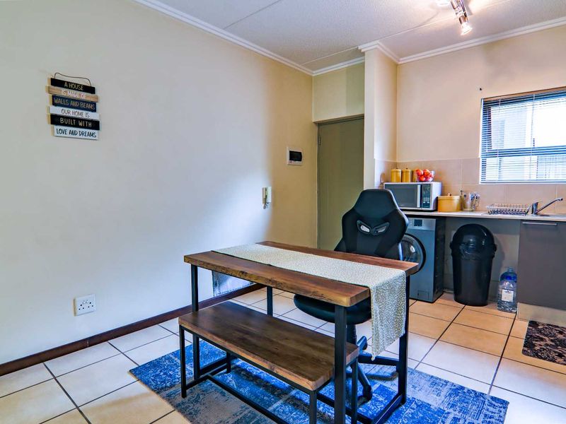 A functional kitchen area featuring tiled flooring, built-in cabinetry, and a tiled backsplash, providing a practical space for daily culinary tasks.