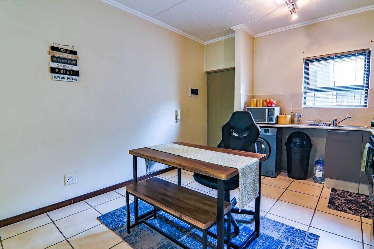 A functional kitchen area featuring tiled flooring, built-in cabinetry, and a tiled backsplash, providing a practical space for daily culinary tasks.