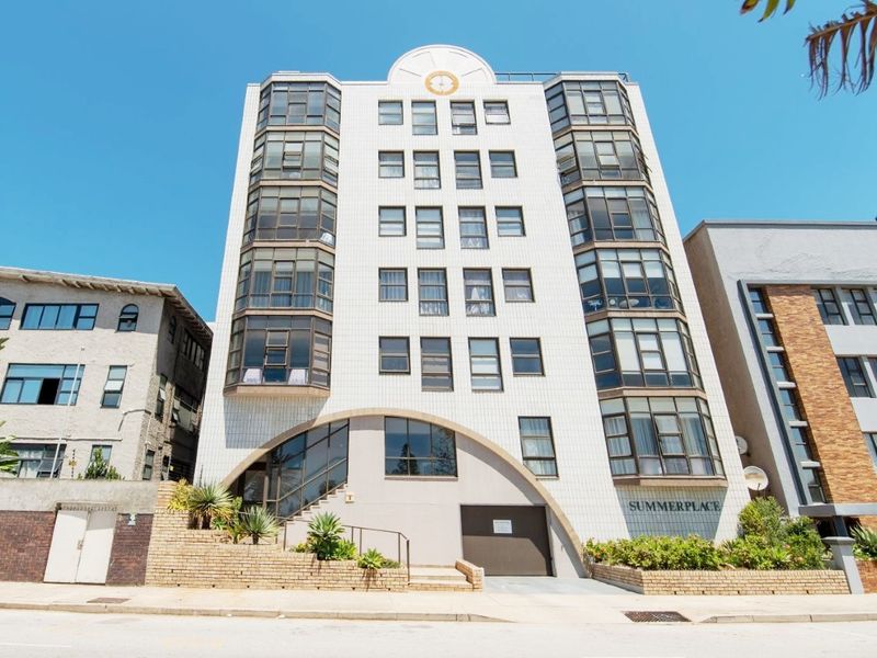 Front elevation of Summerplace apartment building featuring a tiled facade, prominent bay windows, and a secure ground-level garage entrance.