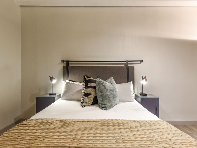 A well-lit bedroom featuring neutral wall tones and modern finishes, providing a comfortable and inviting sleeping space.