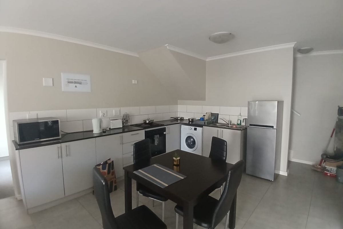 Functional kitchen featuring built-in cabinetry, stone countertops, integrated appliances, and tiled flooring, offering a practical layout for daily meal preparation.