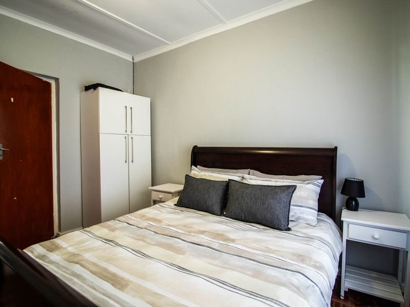 A standard bedroom featuring neutral wall tones, built-in storage, and direct access to an adjoining bathroom area.