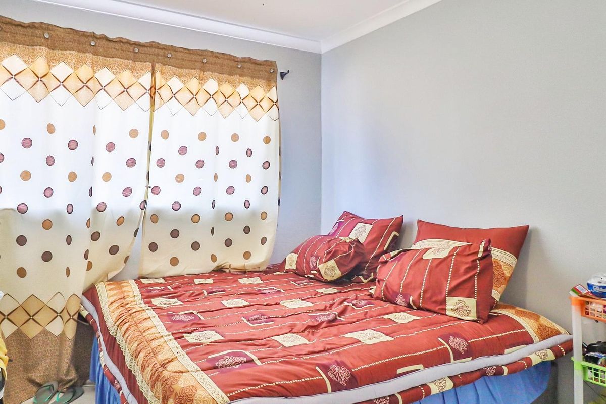 A functional bedroom featuring tiled flooring and neutral wall finishes, providing a clean and simple space.