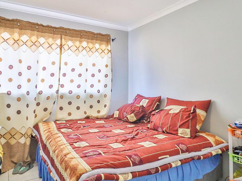A functional bedroom featuring tiled flooring and neutral wall finishes, providing a clean and simple space.