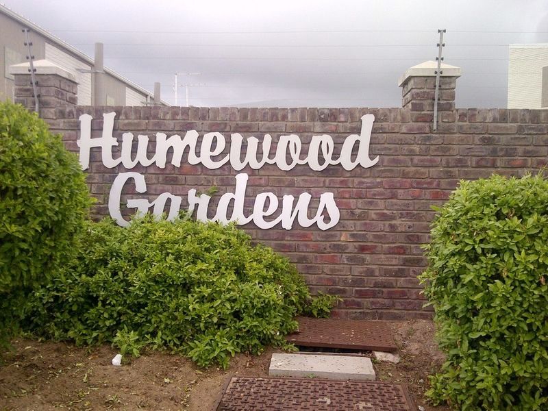 Entrance signage for Humewood Gardens featuring a brick boundary wall with integrated electric fencing.
