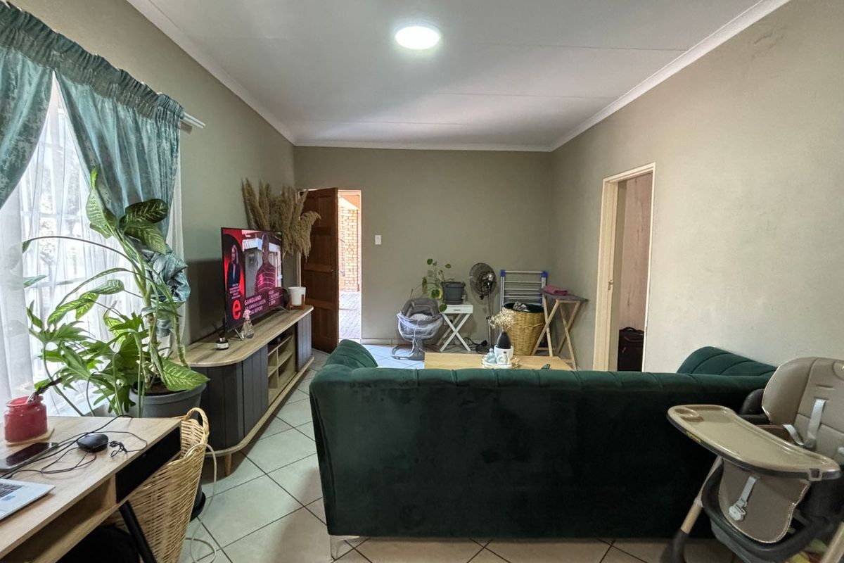 A living room featuring tiled flooring and coved ceilings, providing a functional and neutral space for relaxation.