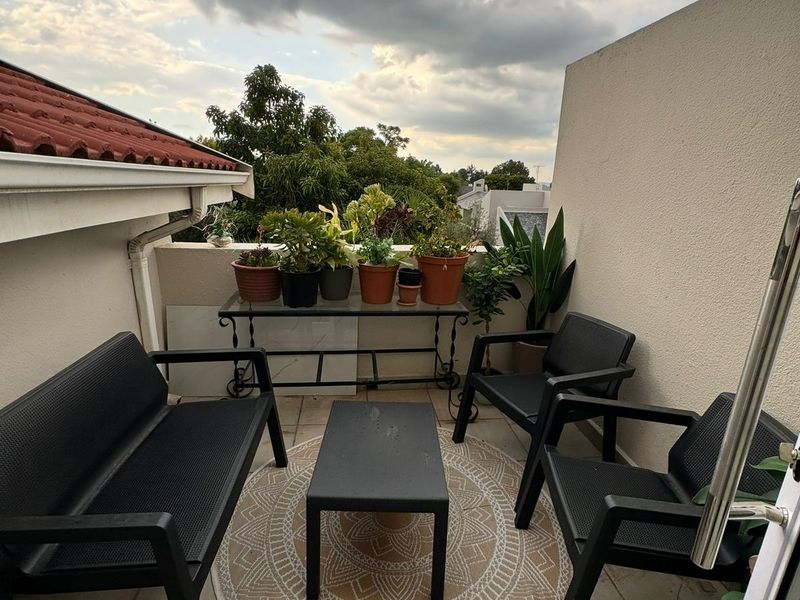 A private balcony featuring tiled flooring and a parapet wall, offering an outdoor space suitable for relaxation.