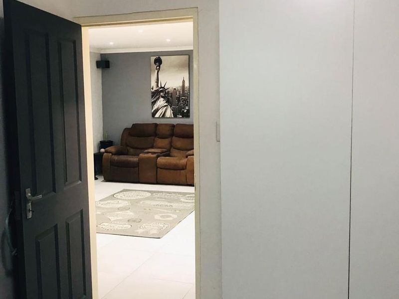 A view from a hallway looking into a living area, featuring tiled flooring and a built-in wardrobe.