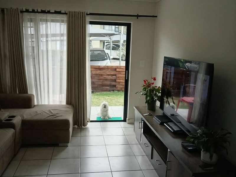 A living room featuring tiled flooring and a sliding glass door that provides direct access to the outdoor area.