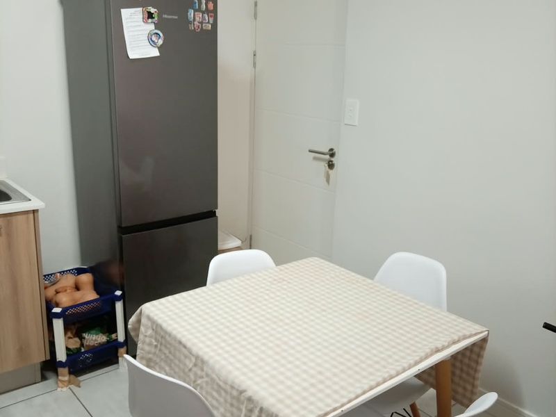 A functional kitchen area featuring tiled flooring and built-in cabinetry, providing a practical space for meal preparation and dining.