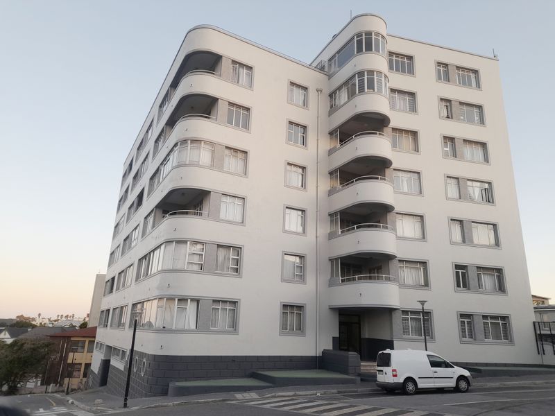 A multi-story apartment building featuring distinctive curved balconies and a clean, well-maintained facade.