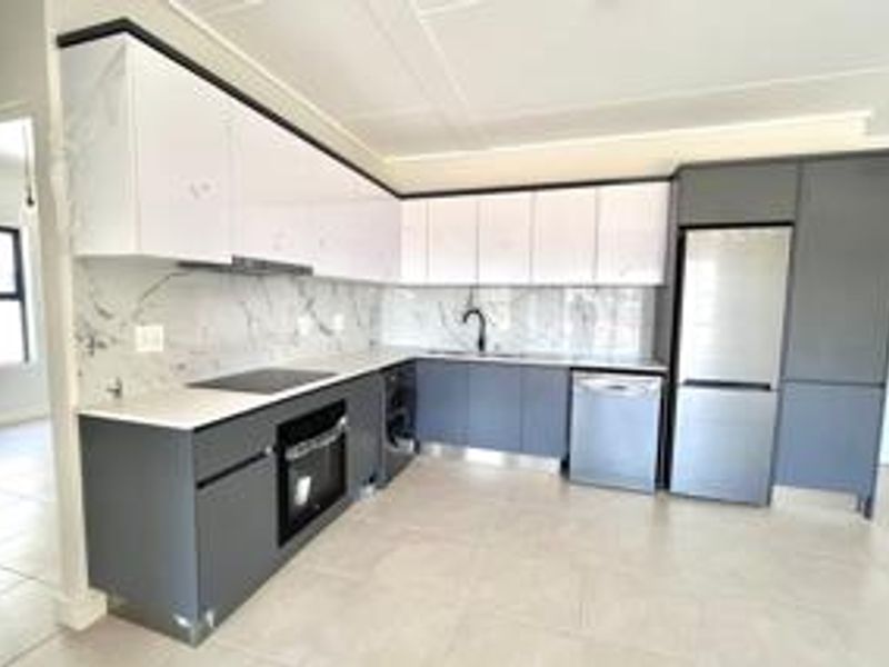 Modern kitchen featuring sleek two-tone cabinetry, marble-look splashbacks, integrated appliances, and high-quality finishes in a clean, contemporary layout.