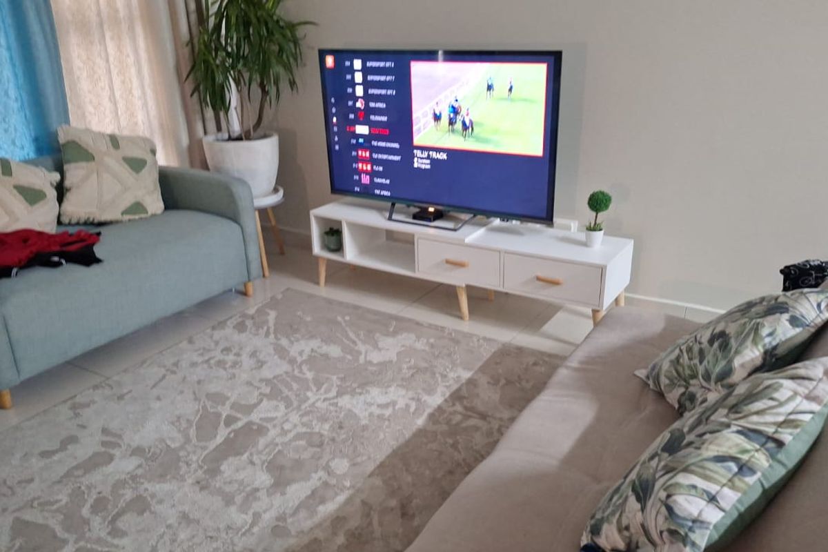 A comfortable living room area featuring tiled flooring and neutral wall finishes, providing a functional space for relaxation and entertainment.
