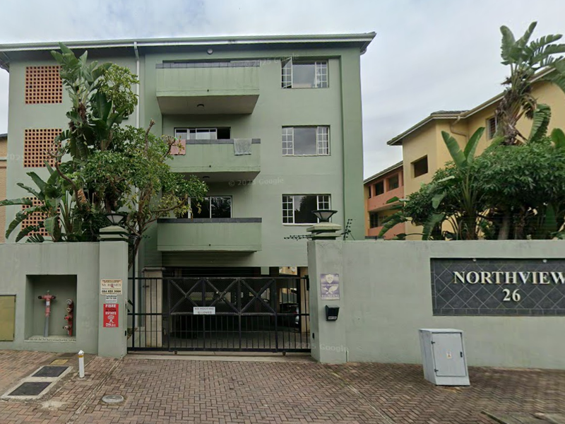 Front elevation of Northview apartment complex featuring a secure gated entrance, perimeter wall, and multi-level balconies.