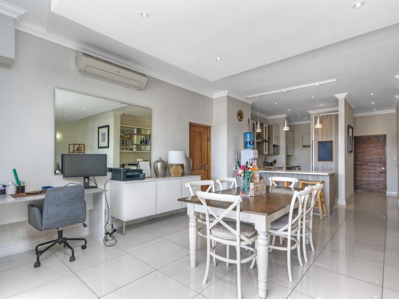 Spacious open-plan living and dining area featuring polished tile flooring, recessed lighting, and a modern kitchen with a central island.