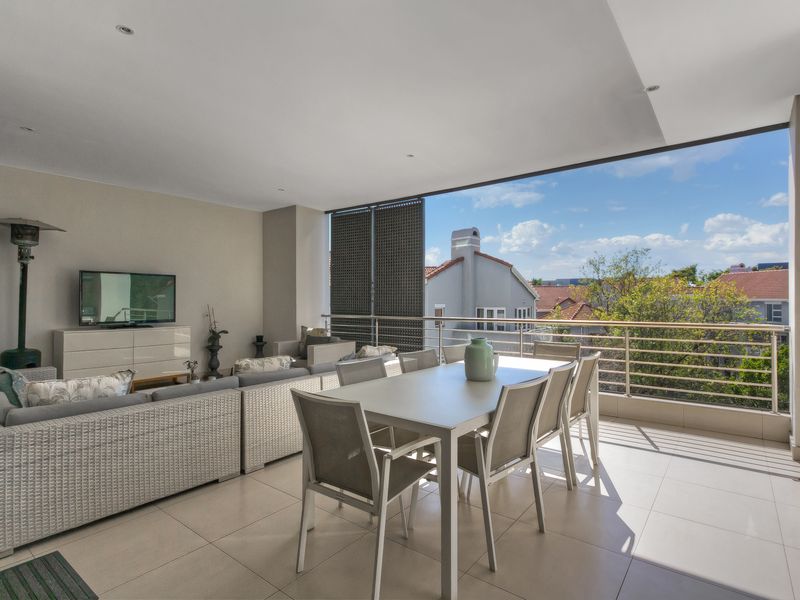 A spacious covered balcony featuring tiled flooring, recessed lighting, and a metal balustrade, offering an ideal outdoor entertainment area with pleasant neighbourhood views.