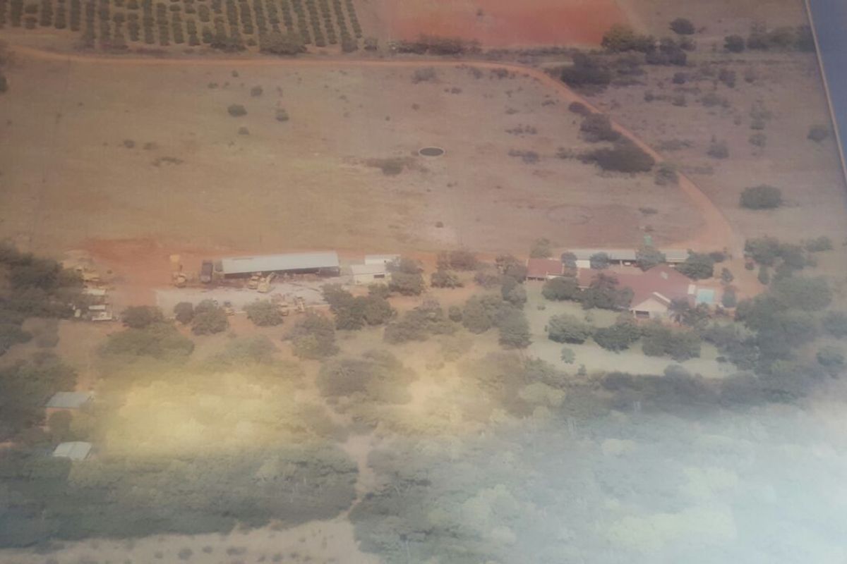 An aerial view of the farm property, showcasing the main dwelling, surrounding land, and outbuildings.