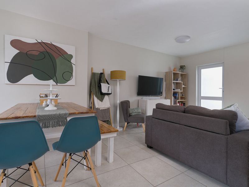 An open-plan living and dining area featuring neutral wall tones and light-colored tiled flooring, providing a functional and bright living space.
