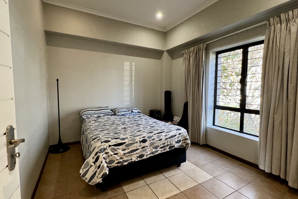 A bedroom featuring tiled flooring, a large window with curtains, and recessed ceiling lighting.