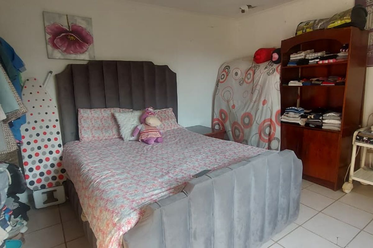 A bedroom featuring tiled flooring and a neutral wall finish, providing a functional space for rest.