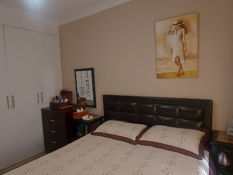 A functional bedroom featuring a built-in wardrobe and neutral wall finishes, providing a comfortable and practical sleeping space.
