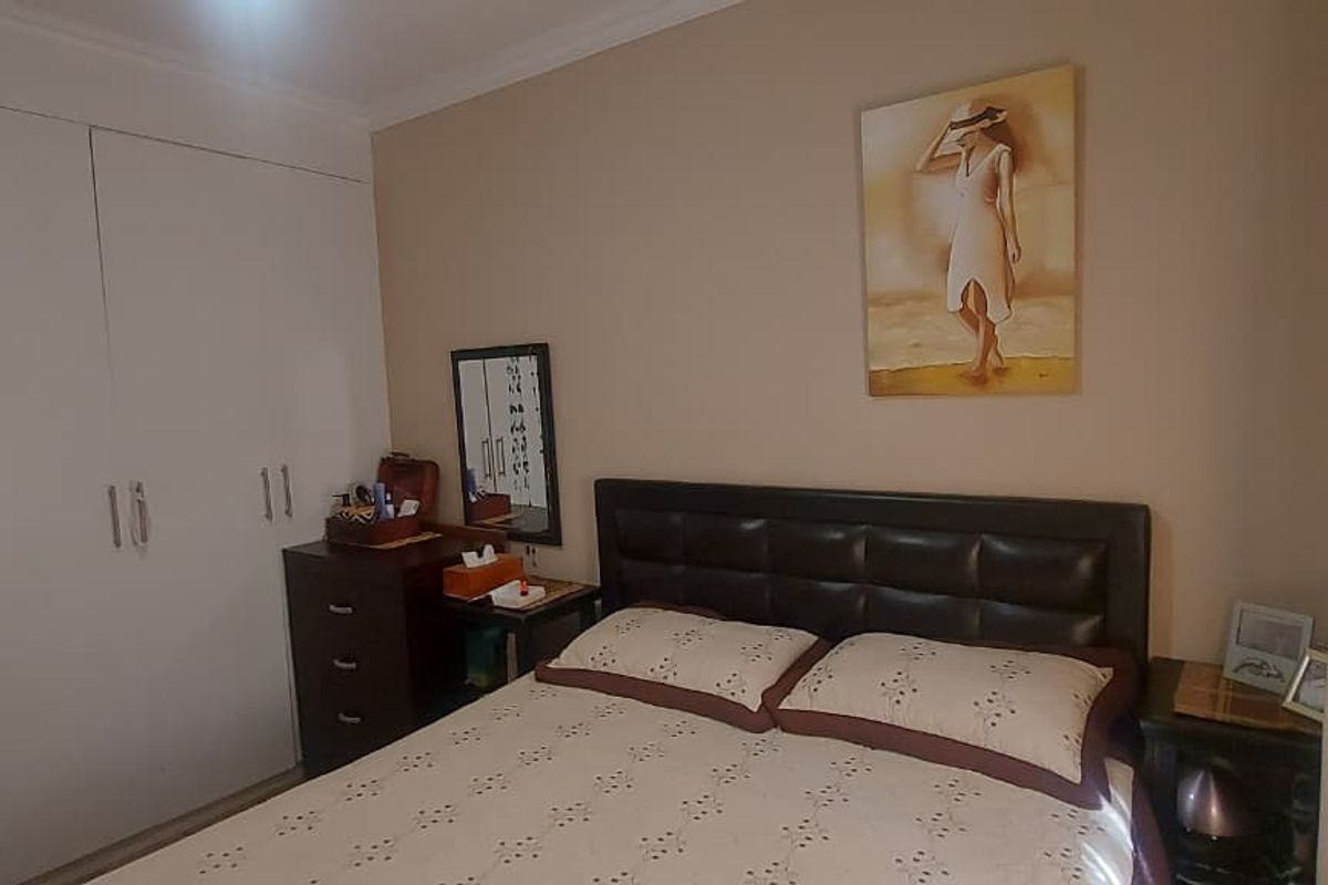 A functional bedroom featuring a built-in wardrobe and neutral wall finishes, providing a comfortable and practical sleeping space.
