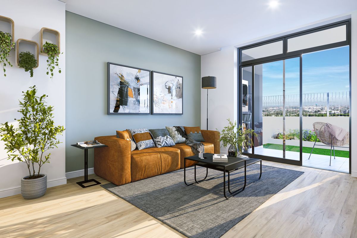 Modern living room featuring light wood-look flooring, a soft green accent wall, and large sliding glass doors leading to a private balcony.