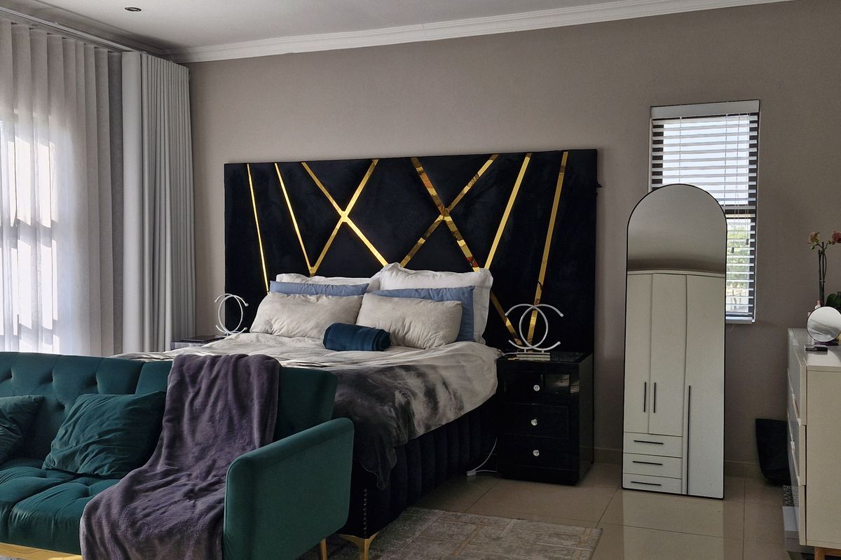 A well-maintained bedroom featuring tiled flooring, neutral wall tones, and large windows with integrated curtain tracks and venetian blinds.