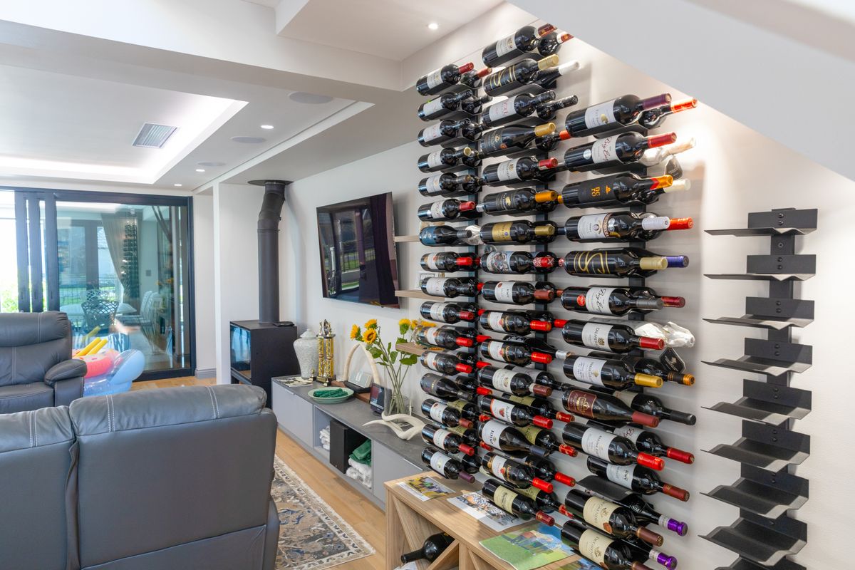 A modern living area featuring a built-in wine rack, a sleek fireplace, and large sliding glass doors leading to an outdoor space.